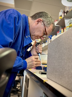 A man uses a pipette in a lab