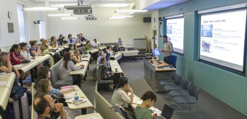 People watching a man speak in a lecture  hall